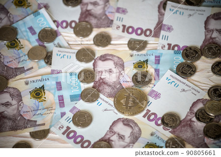 Bitcoin over the ukrainian hryvnia currency. Close up Bitcoin over the ukrainian hryvnia currency. Close up 90805661