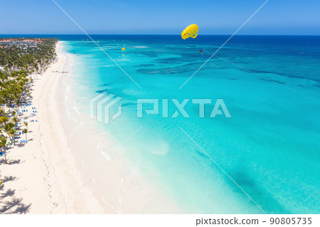 Bounty and pristine sandy shore with coconut palm trees, caribbean sea washes tropical coast. Arenda Gorda beach. Dominican Republic. Aerial view 90805735