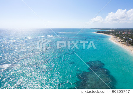 Bounty and pristine coastline with resorts, palm trees, caribbean sea and people having fun on beach. Dominican Republic. Aerial view 90805747