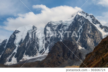Atmospheric scenery of snow mountain ridge above thick low clouds. Scenic view to snowy mountains. Beautiful alpine landscape with mountain range. Atmospheric scenery of snow mountain ridge above thick low clouds. Scenic view to snowy mountains. Beautiful alpine landscape with mountain range. 90806724