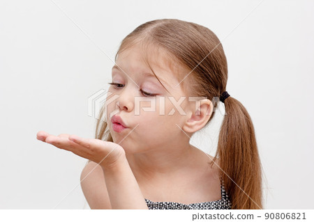 Child blowing on palm 90806821