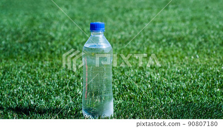 water bottle on green grass for hydration, thirst 90807180