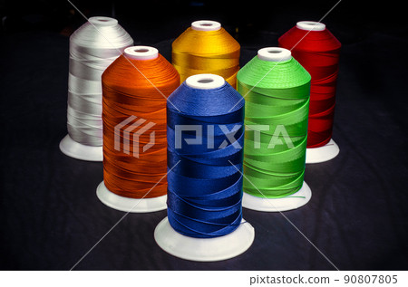 Sewing threads multicolored on a black background Sewing threads multicolored on a black background 90807805