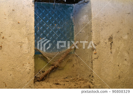 The window in the barn is covered with cobwebs. The window in the barn is covered with cobwebs. 90808329