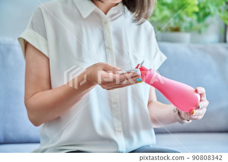 Young woman cleans her face with cotton pads, using cosmetic tonic Young woman cleans her face with cotton pads, using cosmetic tonic 90808342