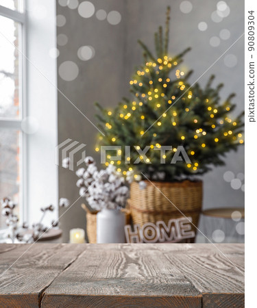 Empty wooden surface and blurred view of room decorated for Christmas Empty wooden surface and blurred view of room decorated for Christmas 90809304