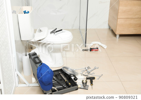 Plumber's tools near toilet bowl in bathroom Plumber's tools near toilet bowl in bathroom 90809321