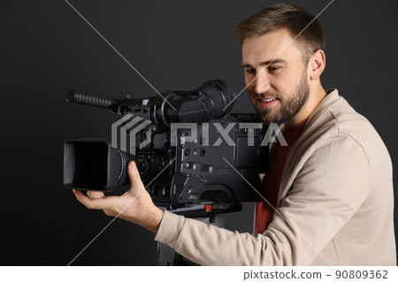 Operator with professional video camera on black background Operator with professional video camera on black background 90809362
