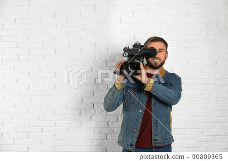 Operator with professional video camera near white brick wall, space for text Operator with professional video camera near white brick wall, space for text 90809365