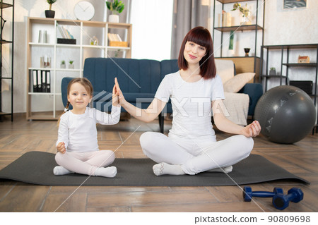 Family, mother and child daughter are engaged in fitness, yoga, exercise at home. 90809698