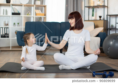 Family, mother and child daughter are engaged in fitness, yoga, exercise at home. Family, mother and child daughter are engaged in fitness, yoga, exercise at home. 90809699