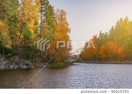 Pine trees on the cliffs of the lake at evening time. 90810793