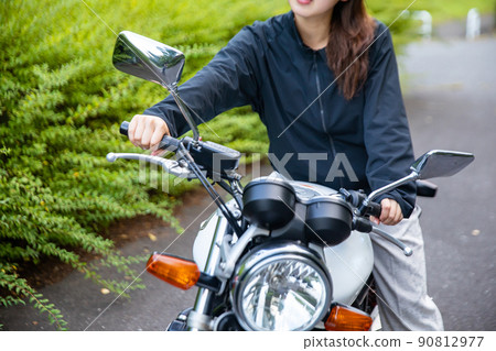 Woman straddling a motorcycle Woman straddling a motorcycle 90812977