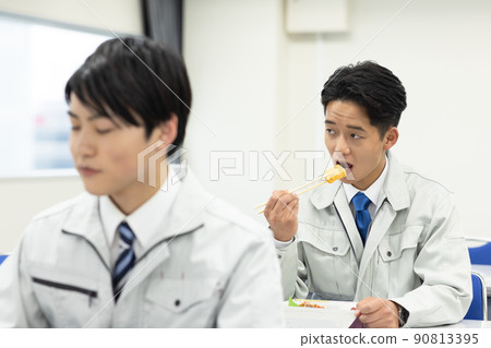 穿著工作服的男女在會議室吃午飯 90813395