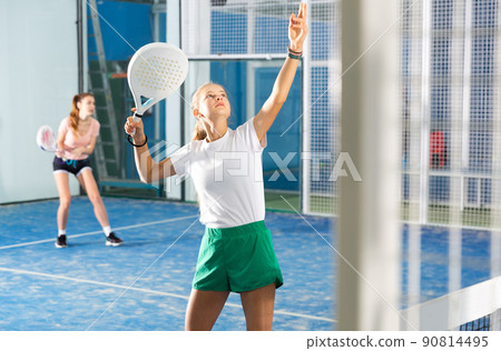 Teenage girl playing padel game on court Teenage girl playing padel game on court 90814495