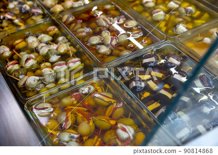 Variety of stuffed marinated olives in glass containers for sale 90814868
