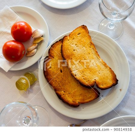 Ingredients for traditional Spanish Pa amb tomaquet on table 90814938