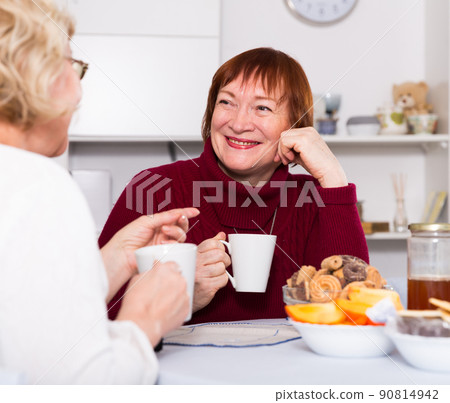 Positive old women drinking tea at the table 90814942