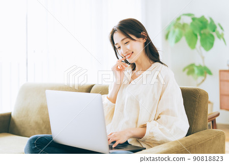 一個女人在沙發上使用電腦 90818823