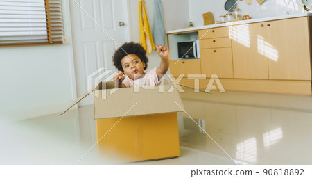 African American Afro Boy playing with carton car indoors at home. African American Afro Boy playing with carton car indoors at home. 90818892