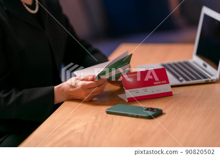 A woman wearing a mourning dress and looking at her passbook A woman wearing a mourning dress and looking at her passbook 90820502