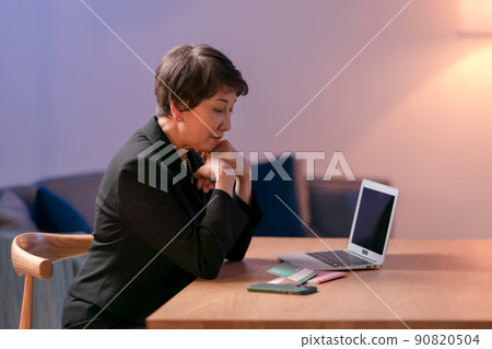 A woman wearing a mourning dress and looking at her passbook 90820504