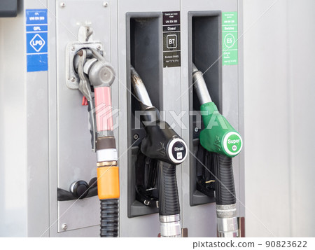 Rome, Italy - May 31, 2022: Fuel pump nozzles for LPG, Diesel B7 and Super E5 in a filling station 90823622