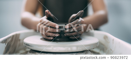 The woman's hands close up, the masterful studio of ceramics works with clay on a potter's wheel. The woman's hands close up, the masterful studio of ceramics works with clay on a potter's wheel. 90823972