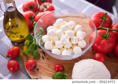 Ingredients for Caprese salad - Mini mozzarella cheese in glass bowl, tomato and basil Ingredients for Caprese salad - Mini mozzarella cheese in glass bowl, tomato and basil 90824455