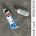 an old halogen lamp with an e 27 base and packaging lie on the floor 90824836
