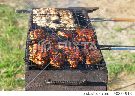 grilled meat on barbecue grill with smoke in green grass grilled meat on barbecue grill with smoke in green grass 90824918