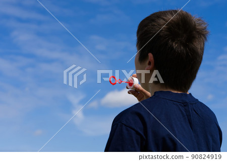 The child blows soap bubbles in nature. The child blows soap bubbles in nature. 90824919