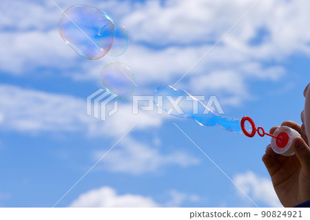 The child blows soap bubbles in nature. The child blows soap bubbles in nature. 90824921