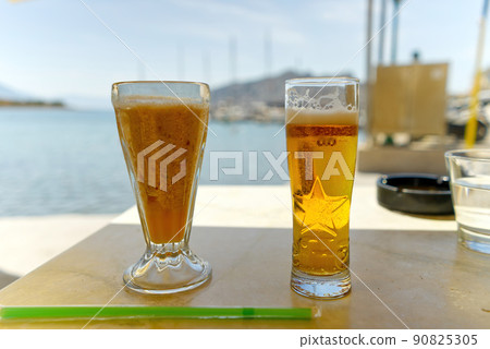 two glasses of cold beer on the table in luxury place with a sea view in summer time in Greece 90825305