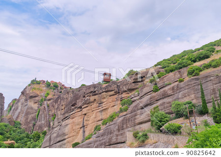 Old funicular in the monastery. Stone monastery in the mountains. Kalabaka, Greece summer cloudy day in Meteora mountain valley. 90825642