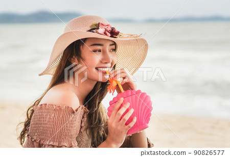 She is drink refreshing cocktail with smiling face at the beach She is drink refreshing cocktail with smiling face at the beach 90826577