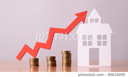 Coins on a table, a red up arrow and house. The concept of the rising price of real estate Coins on a table, a red up arrow and house. The concept of the rising price of real estate 90829099