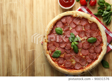 Concept of tasty food with Salami pizza on wooden background 90831576
