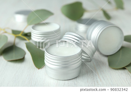 Eco lip balm and leaves on white wooden background Eco lip balm and leaves on white wooden background 90832342