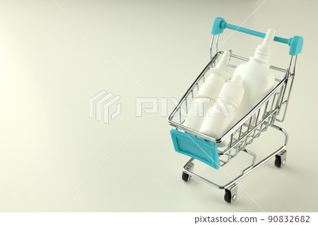 Shop trolley with bottles of nasal spray on white background Shop trolley with bottles of nasal spray on white background 90832682