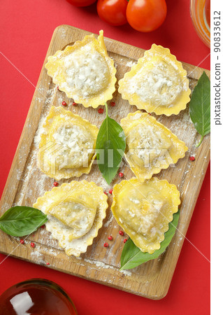 Concept of cooking ravioli on red background Concept of cooking ravioli on red background 90833612