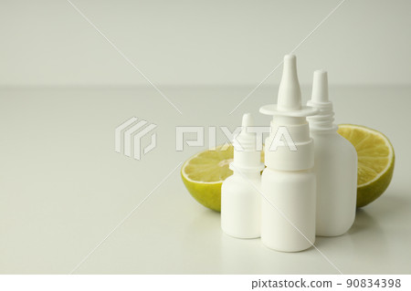 Blank bottles of nasal spray and lime halves on white table Blank bottles of nasal spray and lime halves on white table 90834398