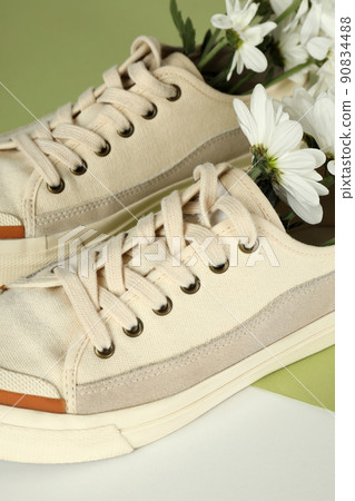 Pair of sneakers with flowers on two tone background 90834488