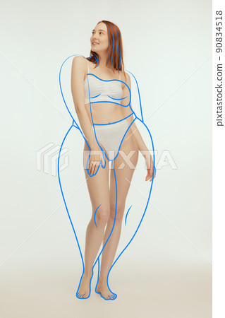 Full-length portrait of slim woman posing in underwear isolated over grey studio background. Drawn lines around body before losing weight. Full-length portrait of slim woman posing in underwear isolated over grey studio background. Drawn lines around body before losing weight. 90834518