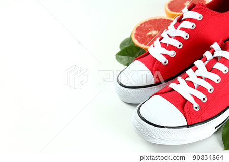 Red sneakers and grapefruit with leaves on white background Red sneakers and grapefruit with leaves on white background 90834864
