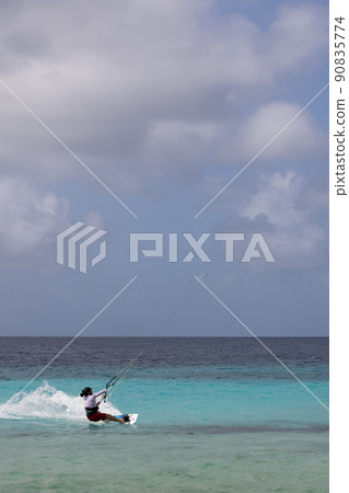 Unrecognisable person practicing kiteboarding in stormy weather. Unrecognisable person practicing kiteboarding in stormy weather. 90835774