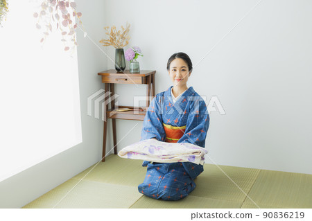 A woman in a kimono folding a yukata A woman in a kimono folding a yukata 90836219