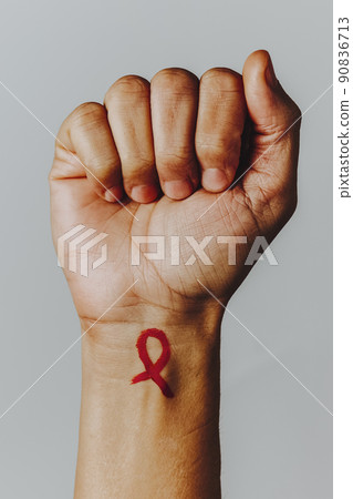 AIDS red awareness ribbon painted in his wrist AIDS red awareness ribbon painted in his wrist 90836713