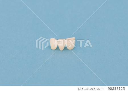 Metal free ceramic teeth implant dental crowns isolated on a blue background.  90838125