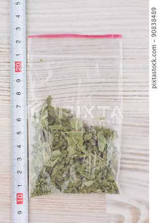 expert analysis of the contents of the package, with material evidence, the suspected presence of drugs, the package of stuff is on the table next to a ruler expert analysis of the contents of the package, with material evidence, the suspected presence of drugs, the package of stuff is on the table next to a ruler 90838489